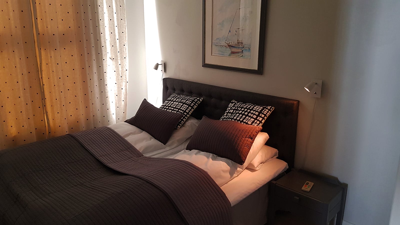 a bed with pillows and a lamp in a room