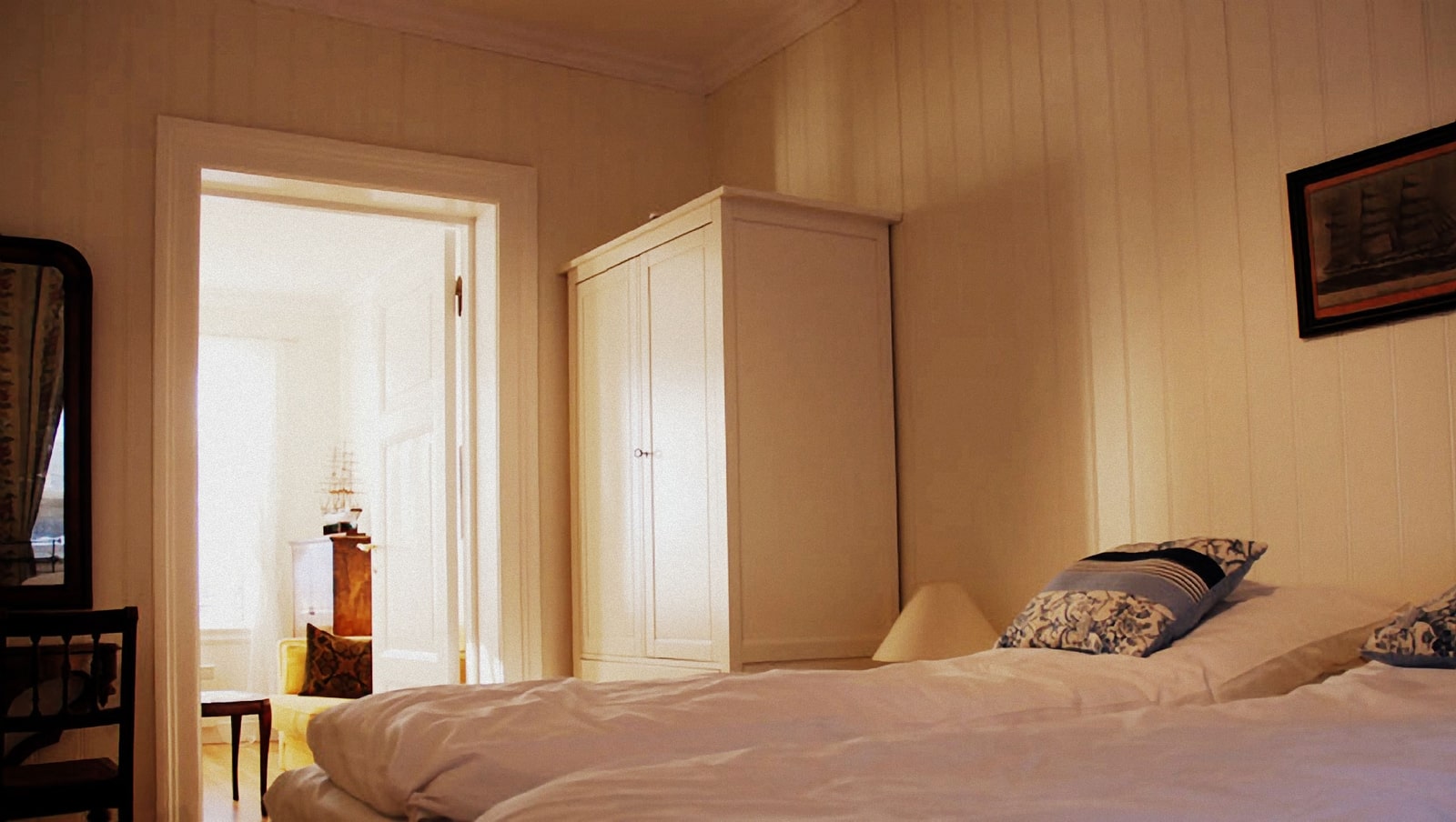 a bedroom with a white cabinet and a bed