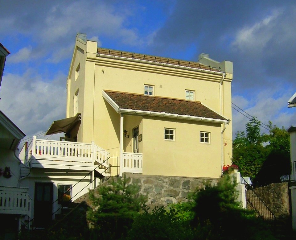 a yellow house with a white railing