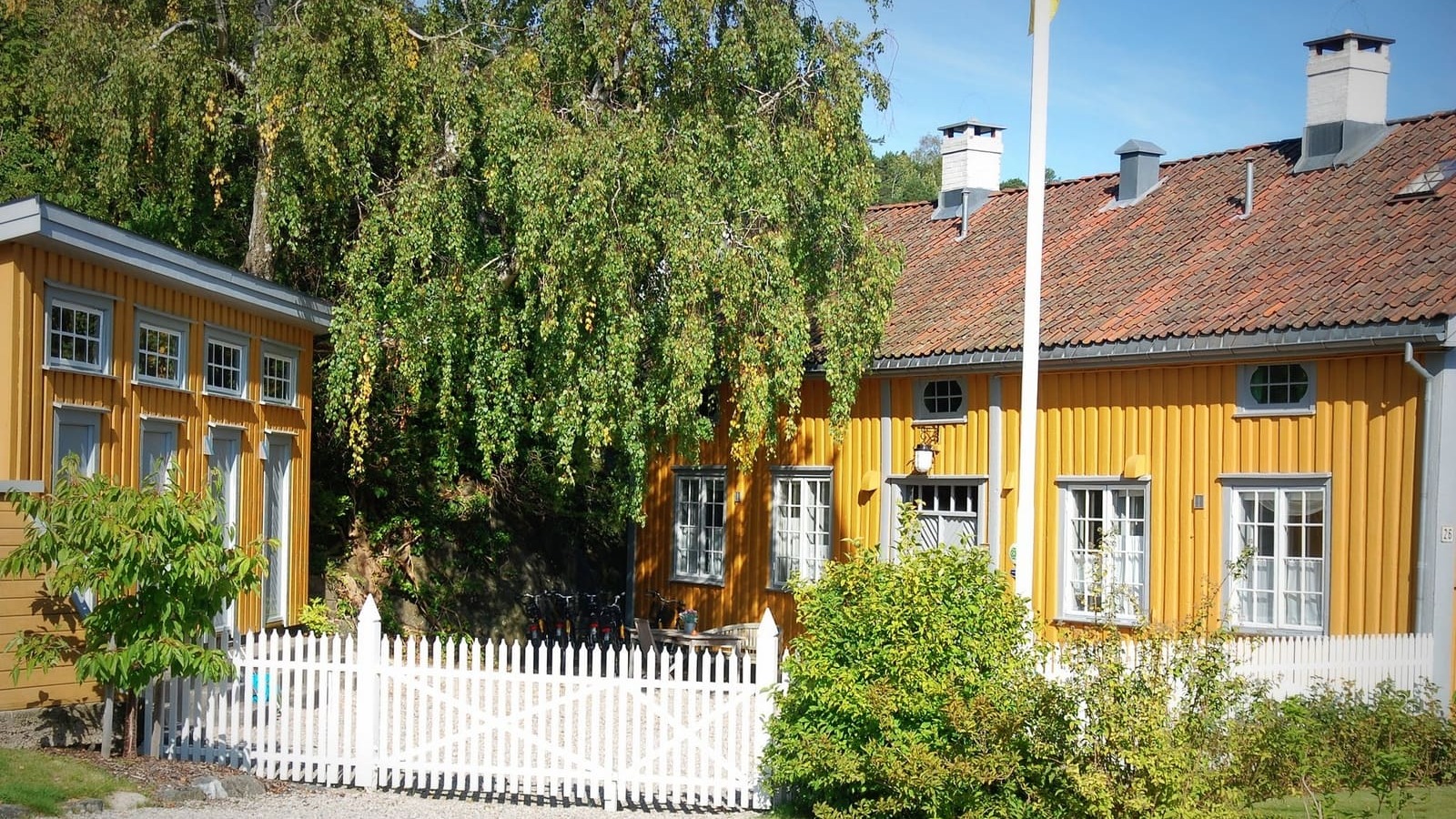a yellow house with a white picket fence