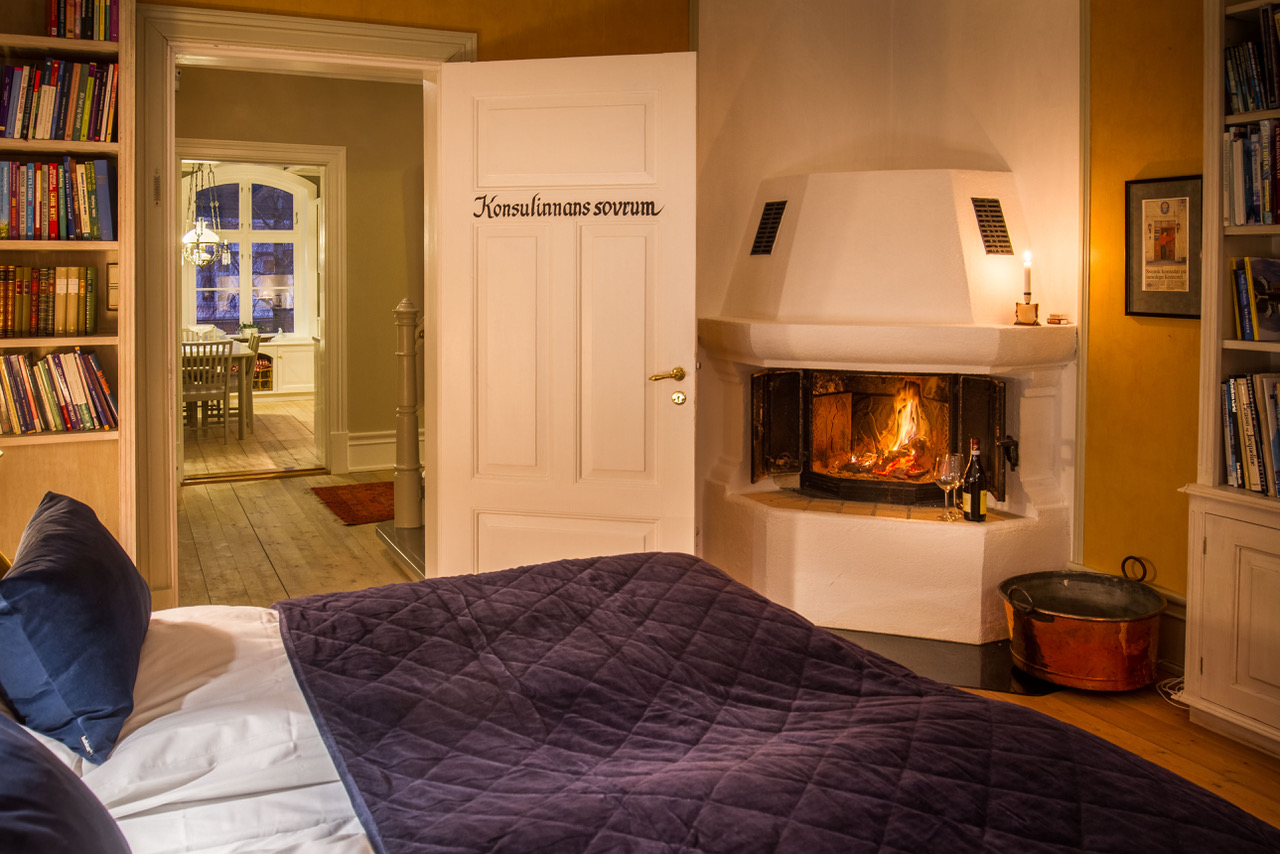 a bed with a blanket and a fireplace in a room