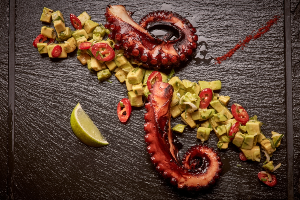 a plate of food with a slice of lime and a piece of avocado
