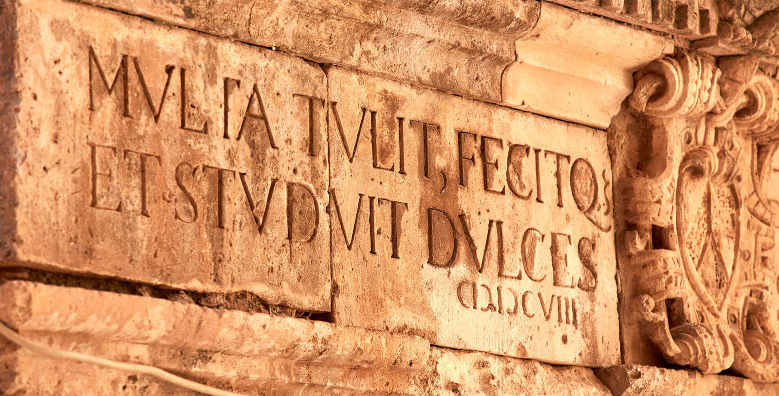 a stone wall with engraved letters