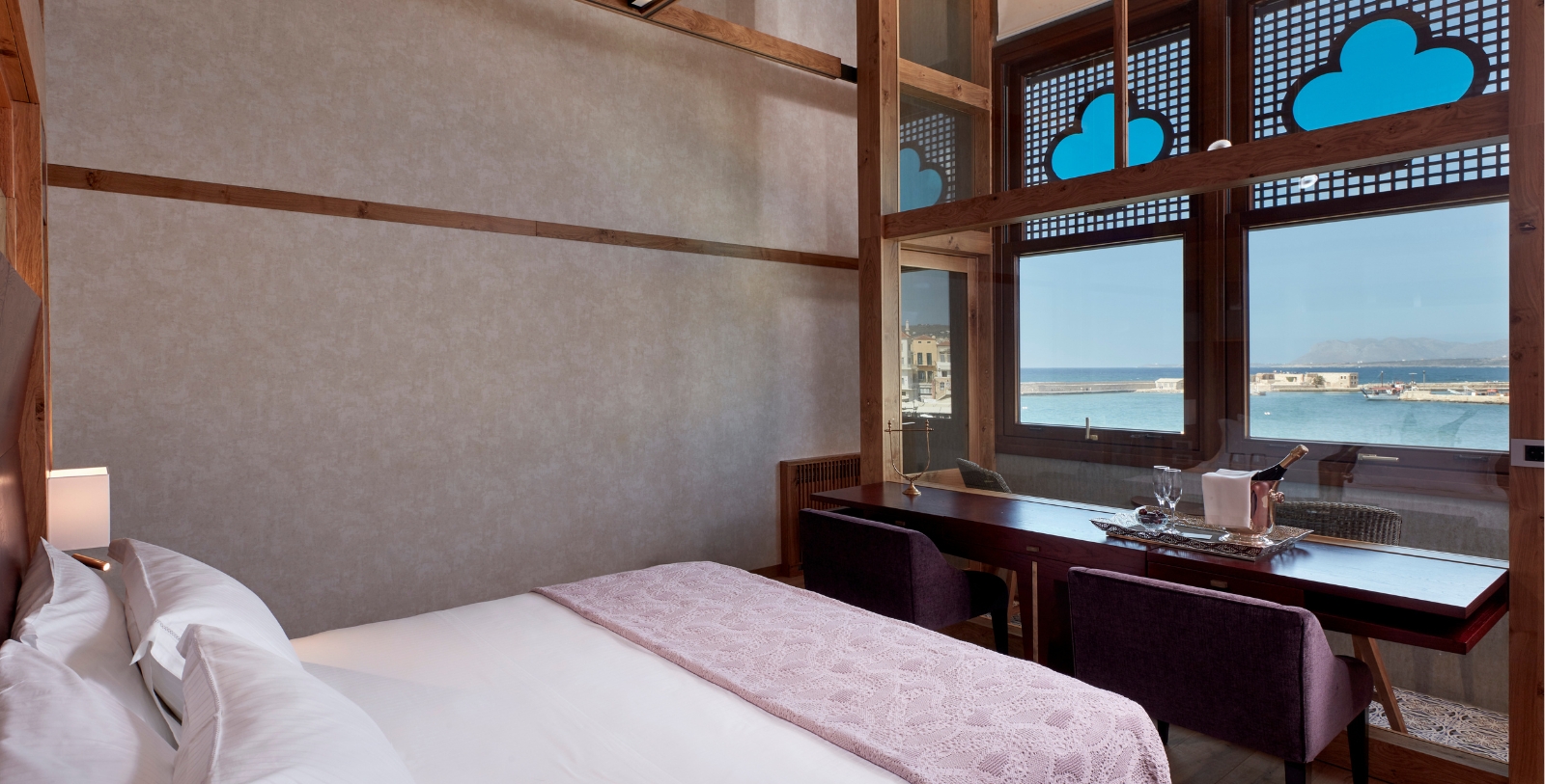 a room with a bed and a desk and chairs