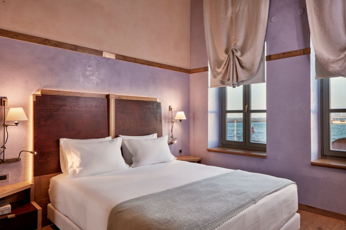 a bed with a wood headboard and a lamp