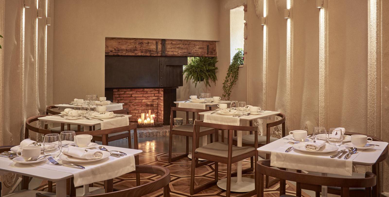 a room with tables and chairs and a fireplace