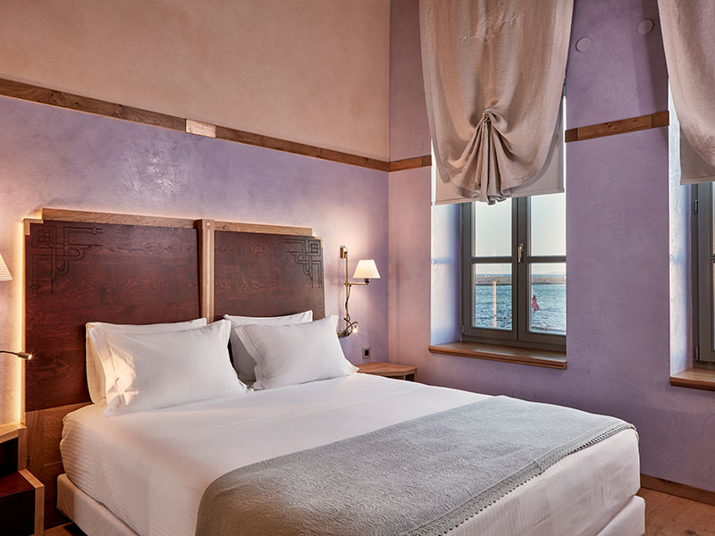 a bed with a wood headboard and a lamp