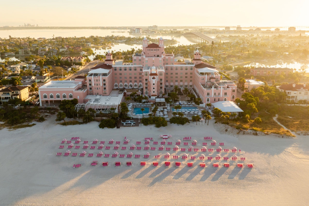 a large building with a beach and chairs
