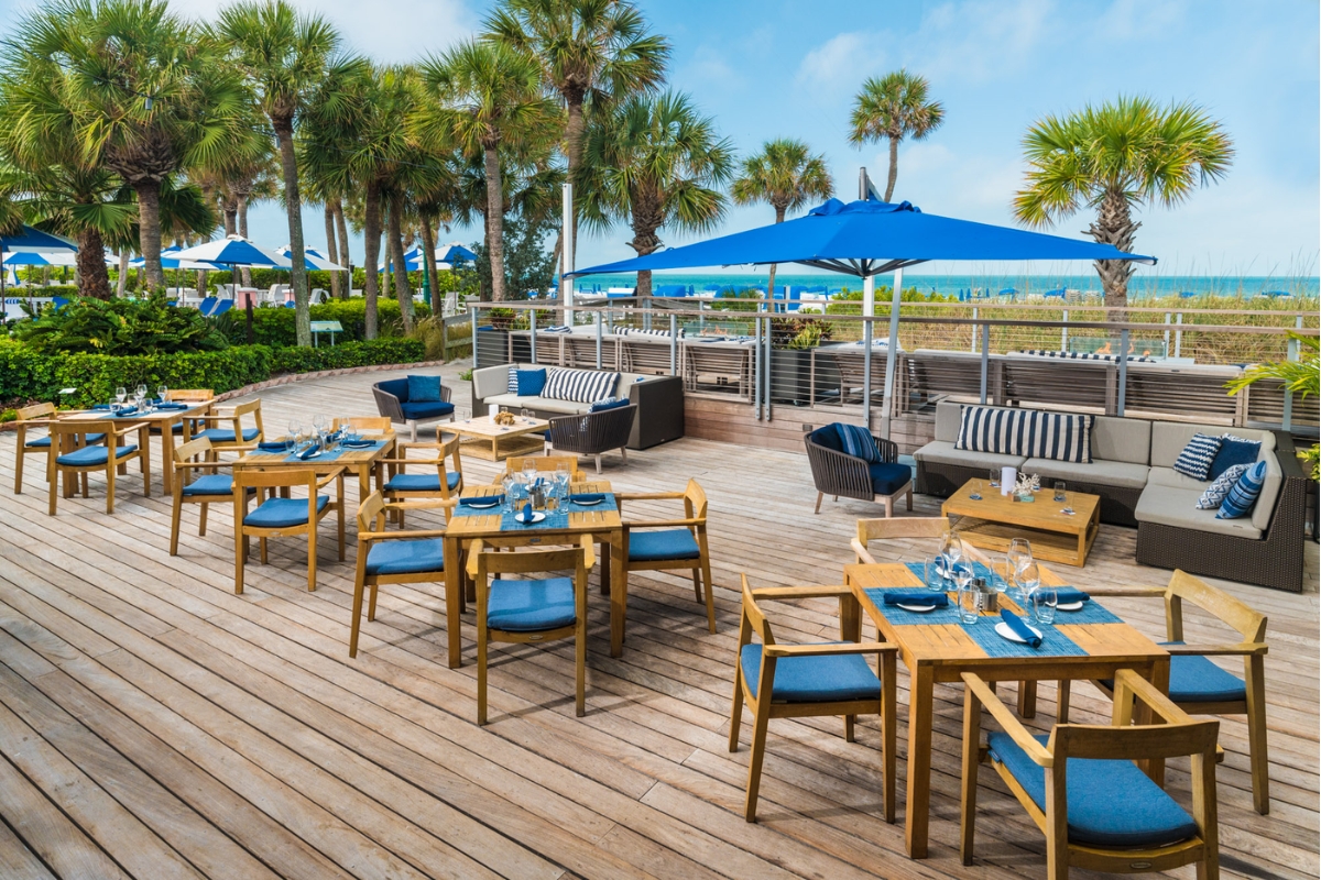 a patio with tables and chairs and umbrellas