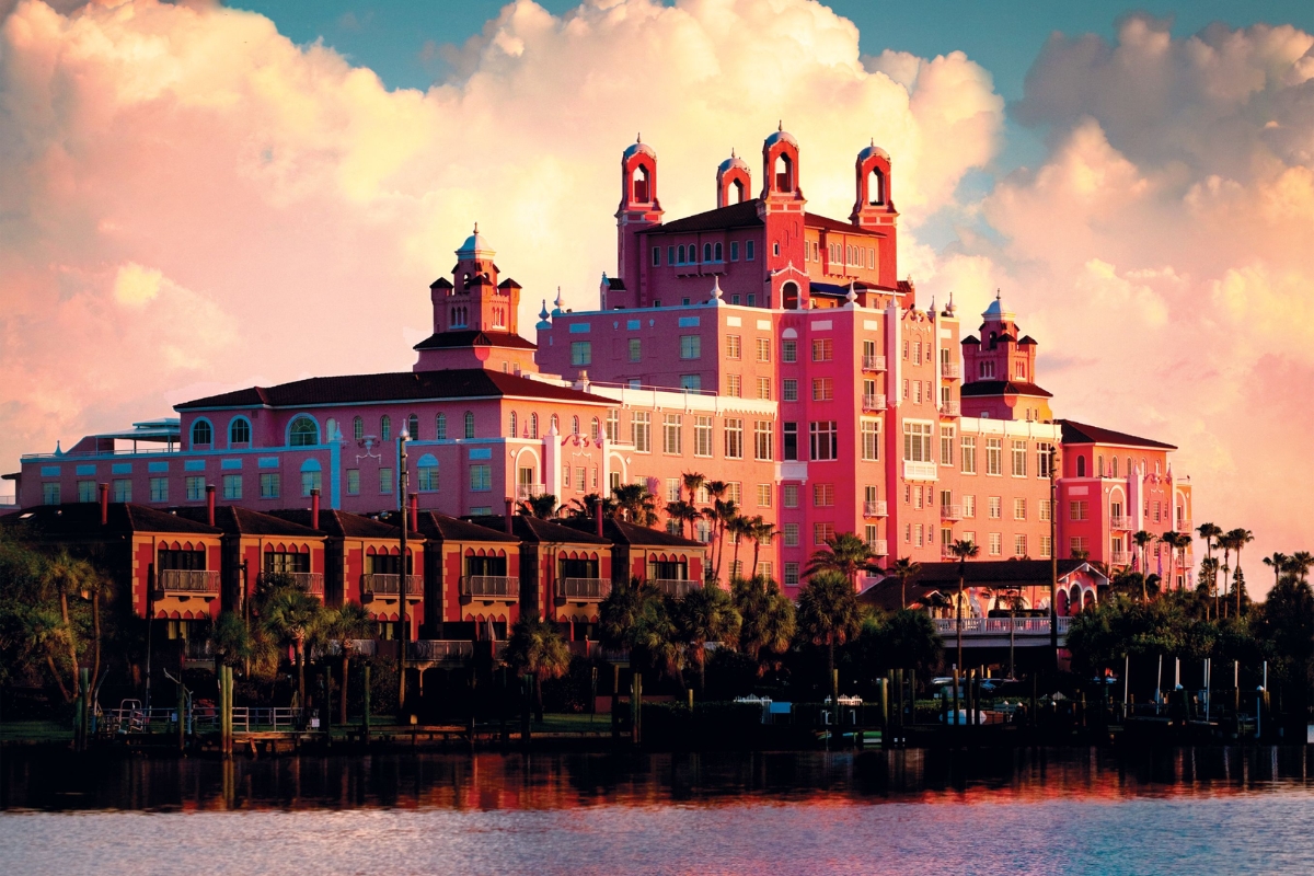 a pink building next to a body of water