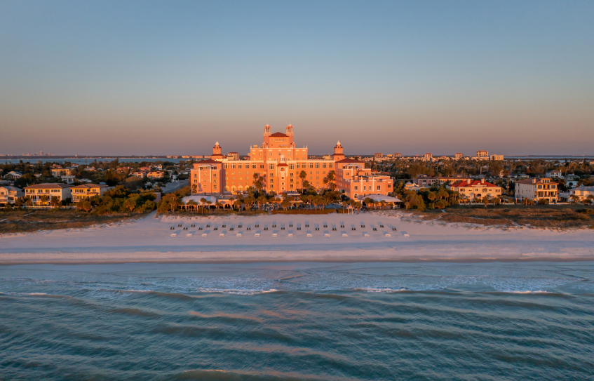 a large building with a beach and trees