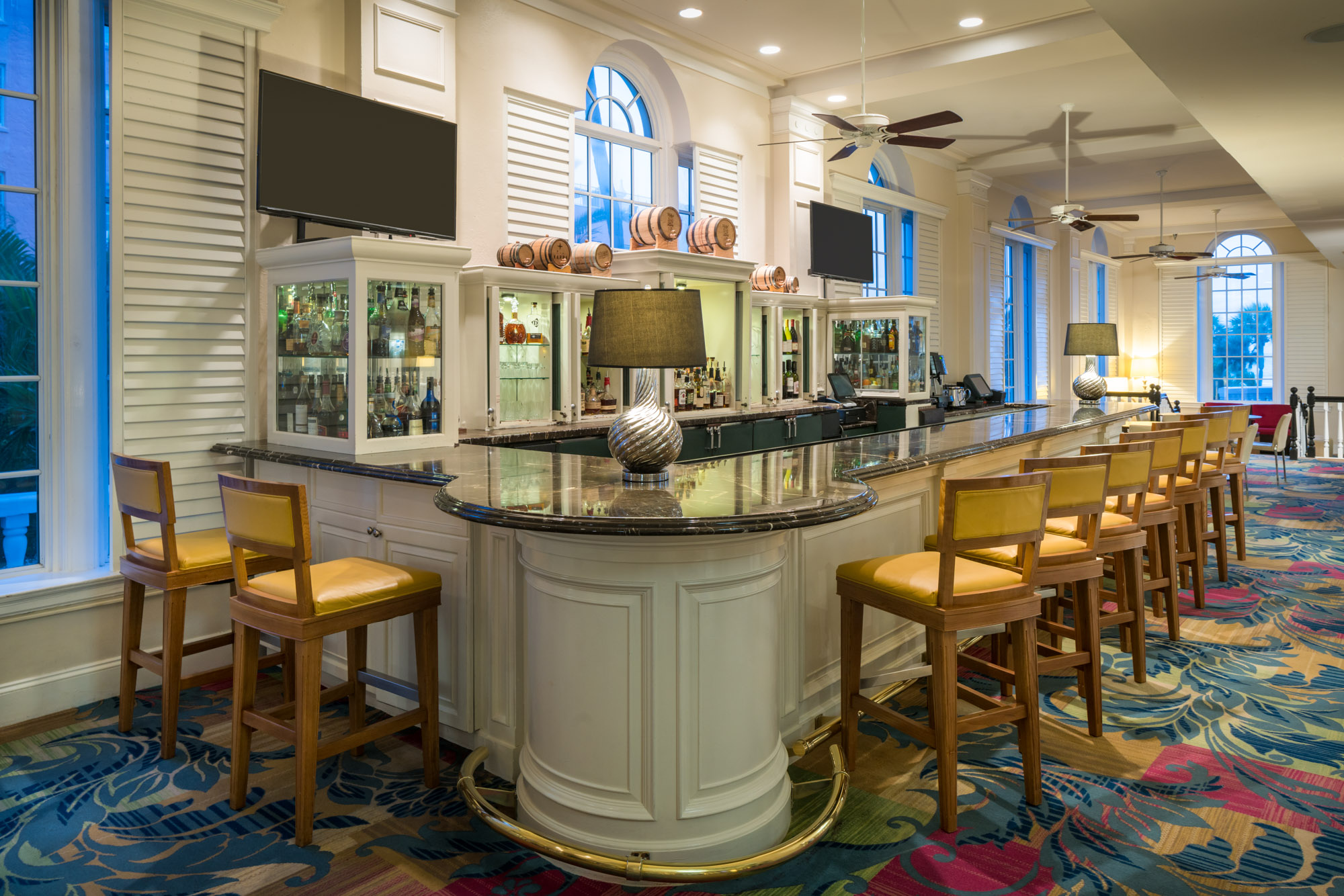 a bar with a black counter and chairs