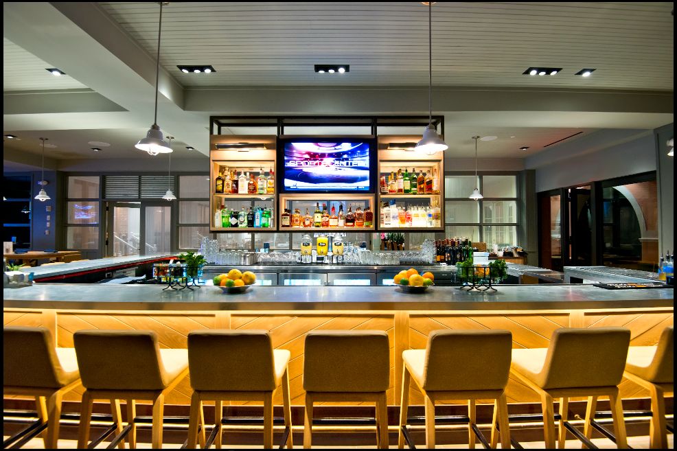 a bar with chairs and a television on the wall