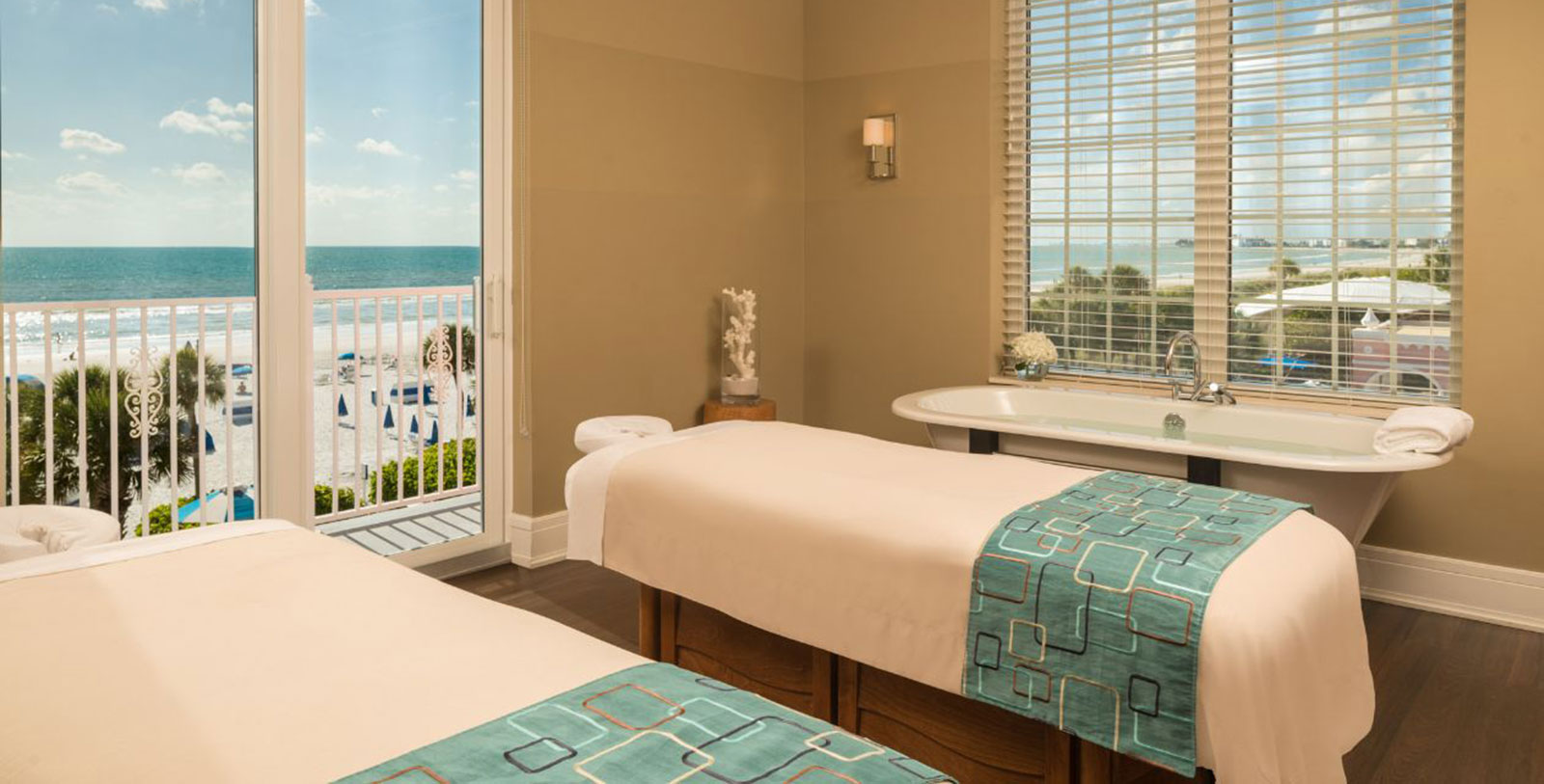a massage table in a room with a view of the beach
