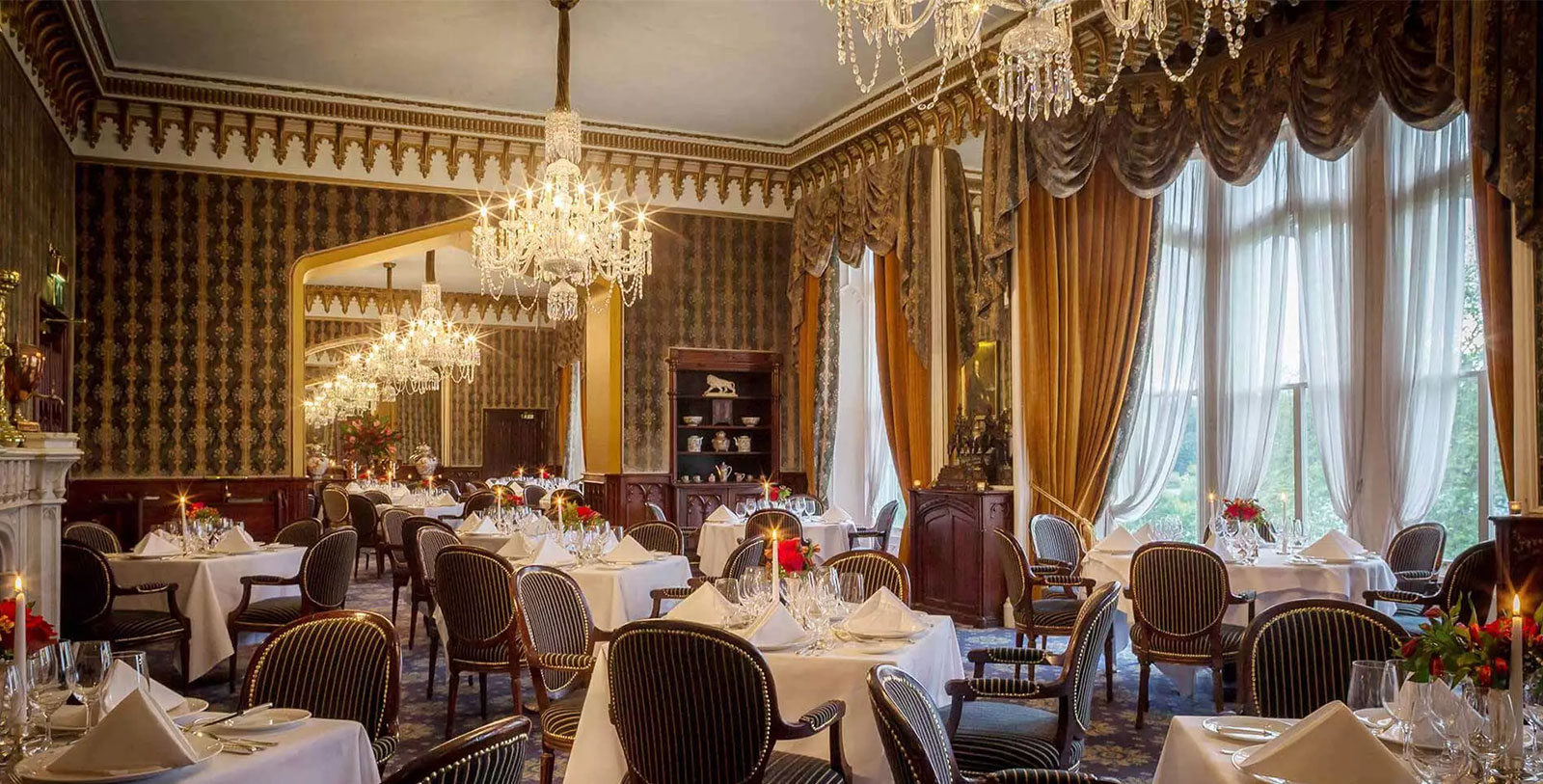 a room with tables and chairs and chandeliers