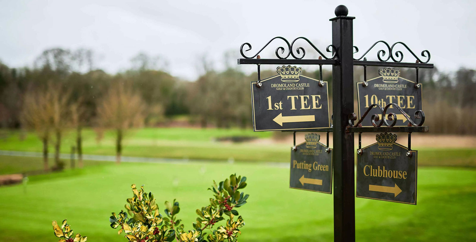 a sign post with a golf course in the background