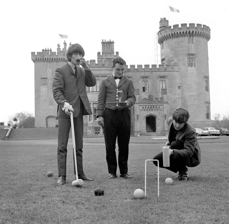 a group of men playing croquet