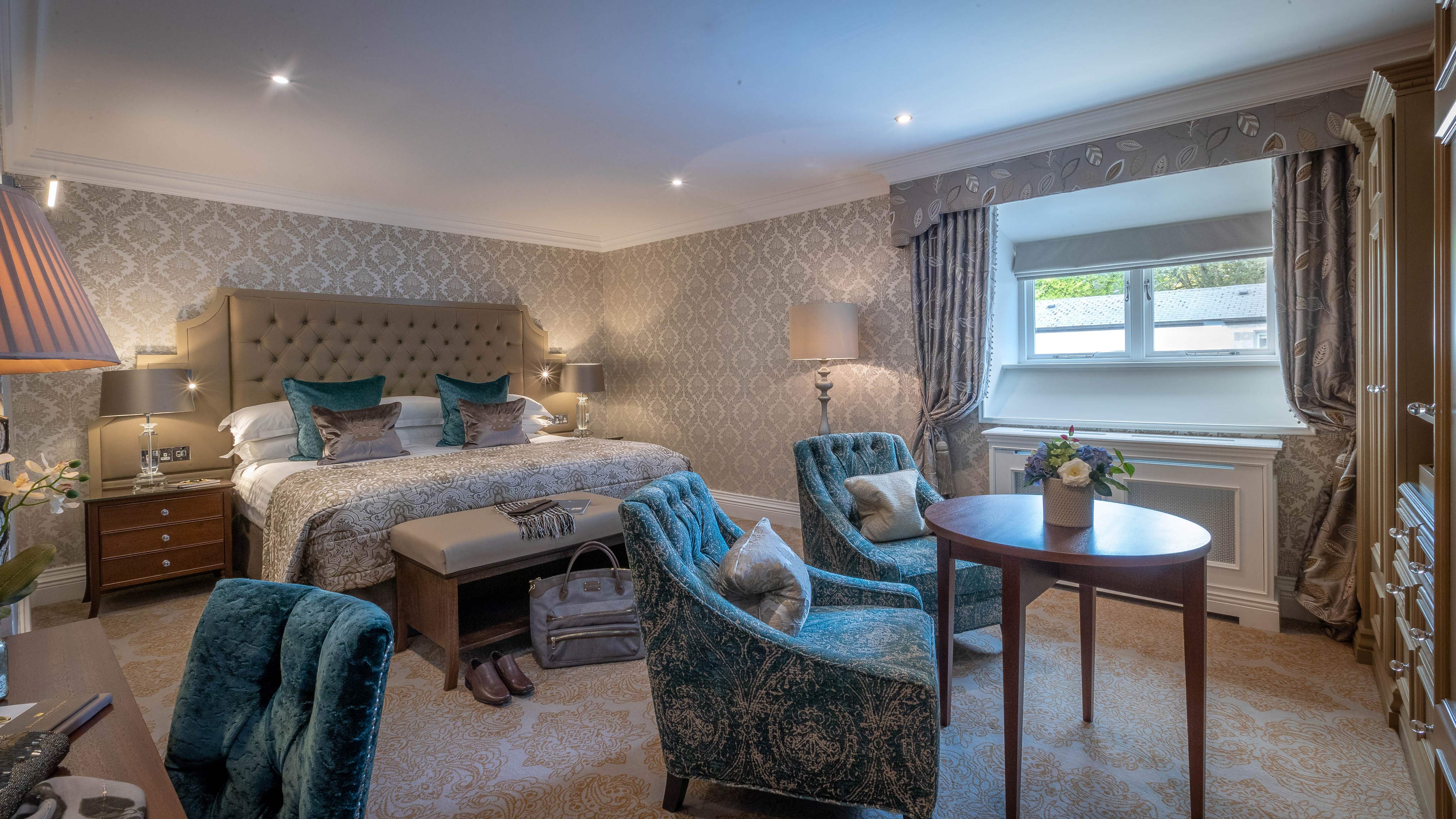 a room with a bed and chairs
