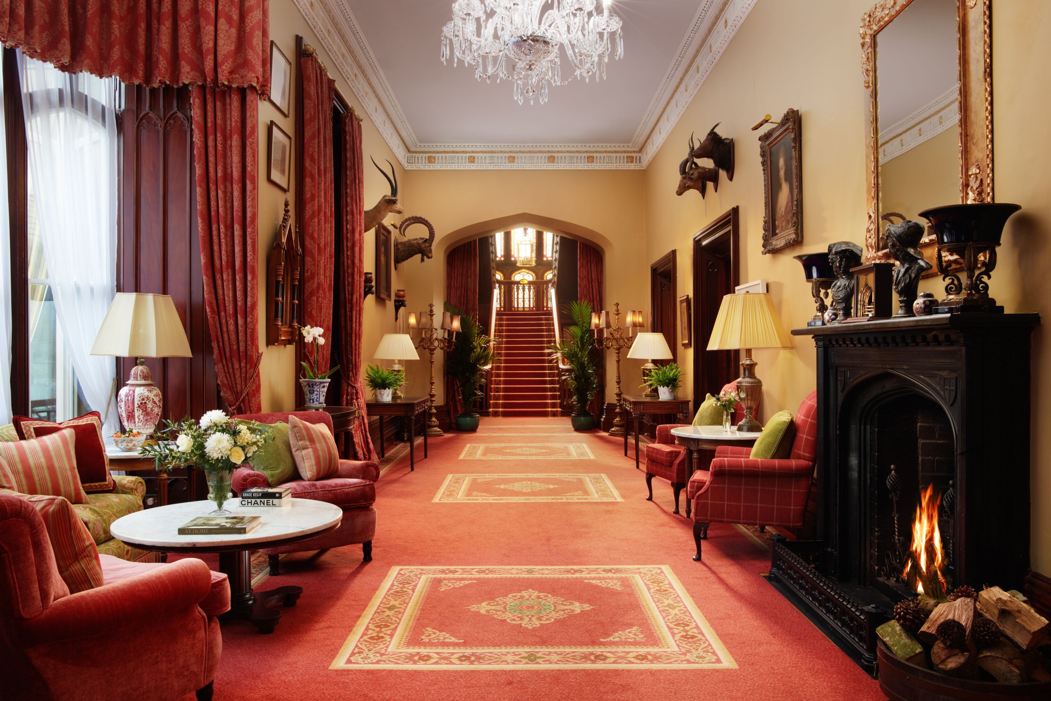 a hallway with a chandelier and chairs