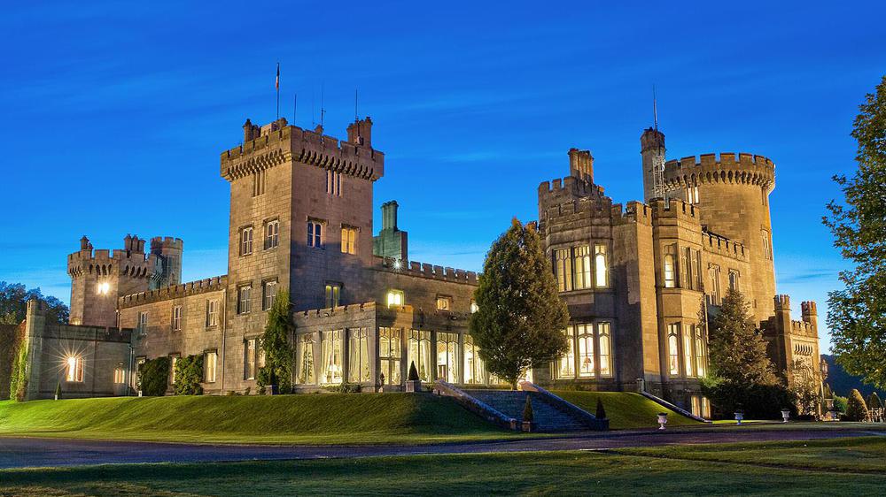 a castle with a lawn and trees with Belvoir Castle in the background