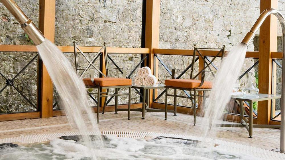 a water fountain with a waterfall and chairs
