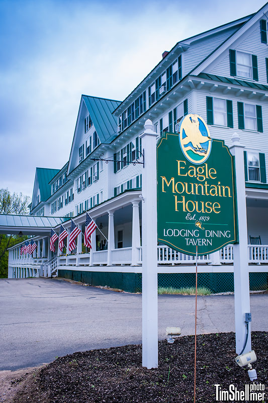 a sign on a post in front of a large white building