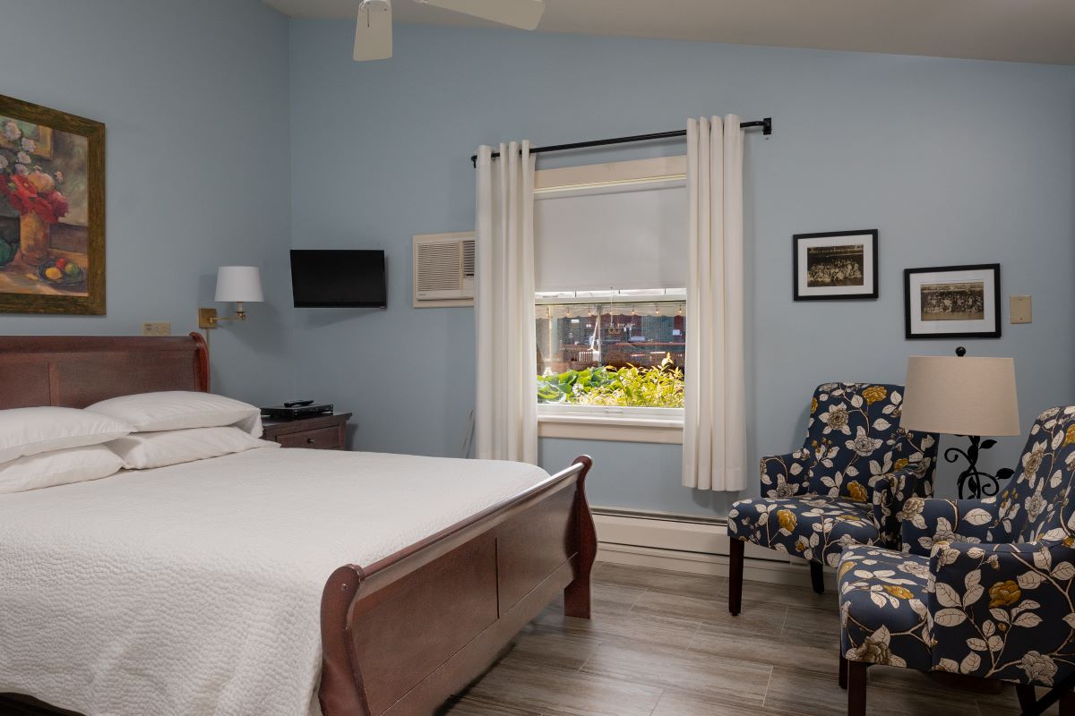 a bedroom with a bed and chairs