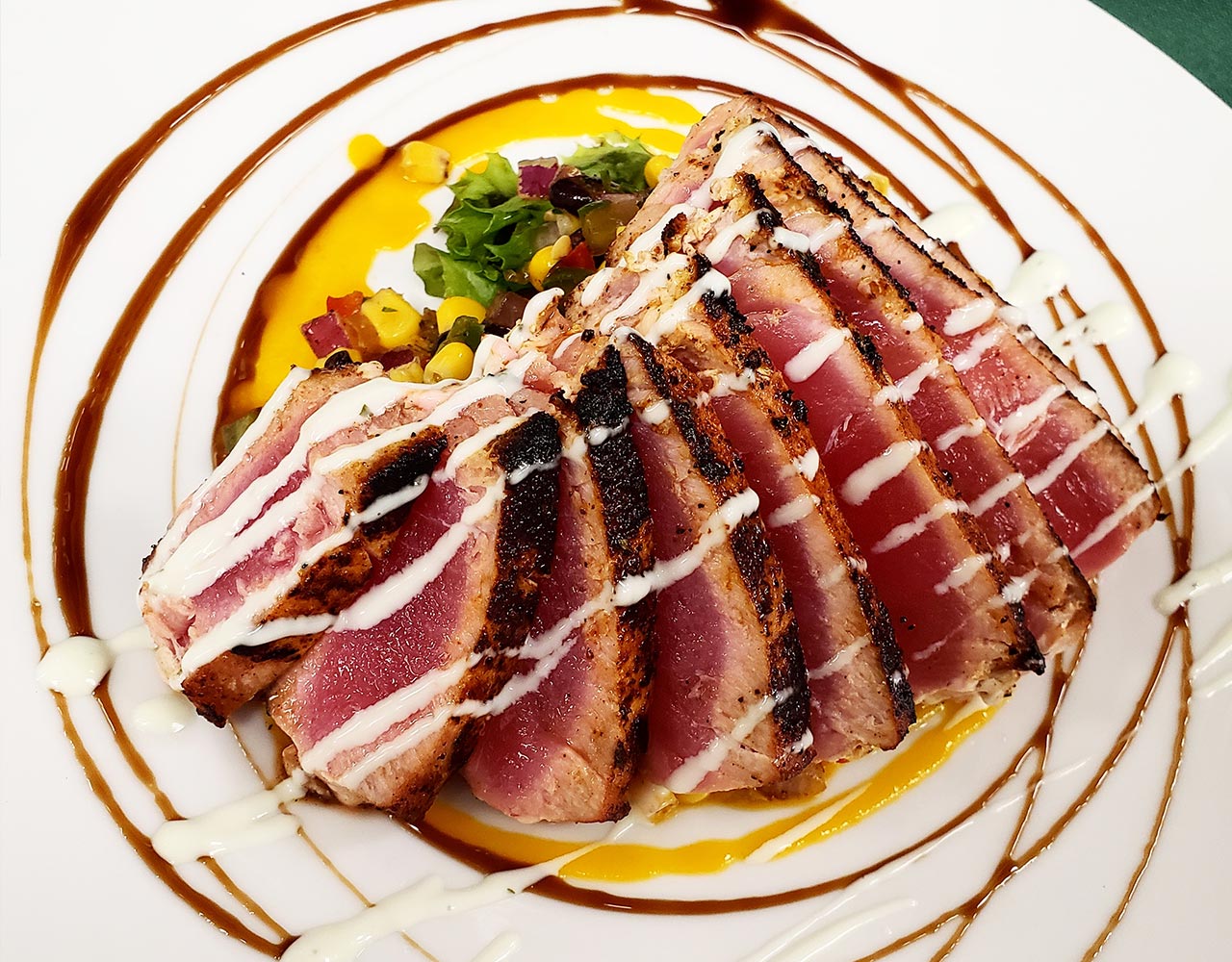 a plate of food with sauce and slices of tuna