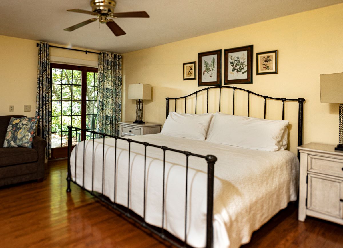 a bed with a metal frame and a ceiling fan
