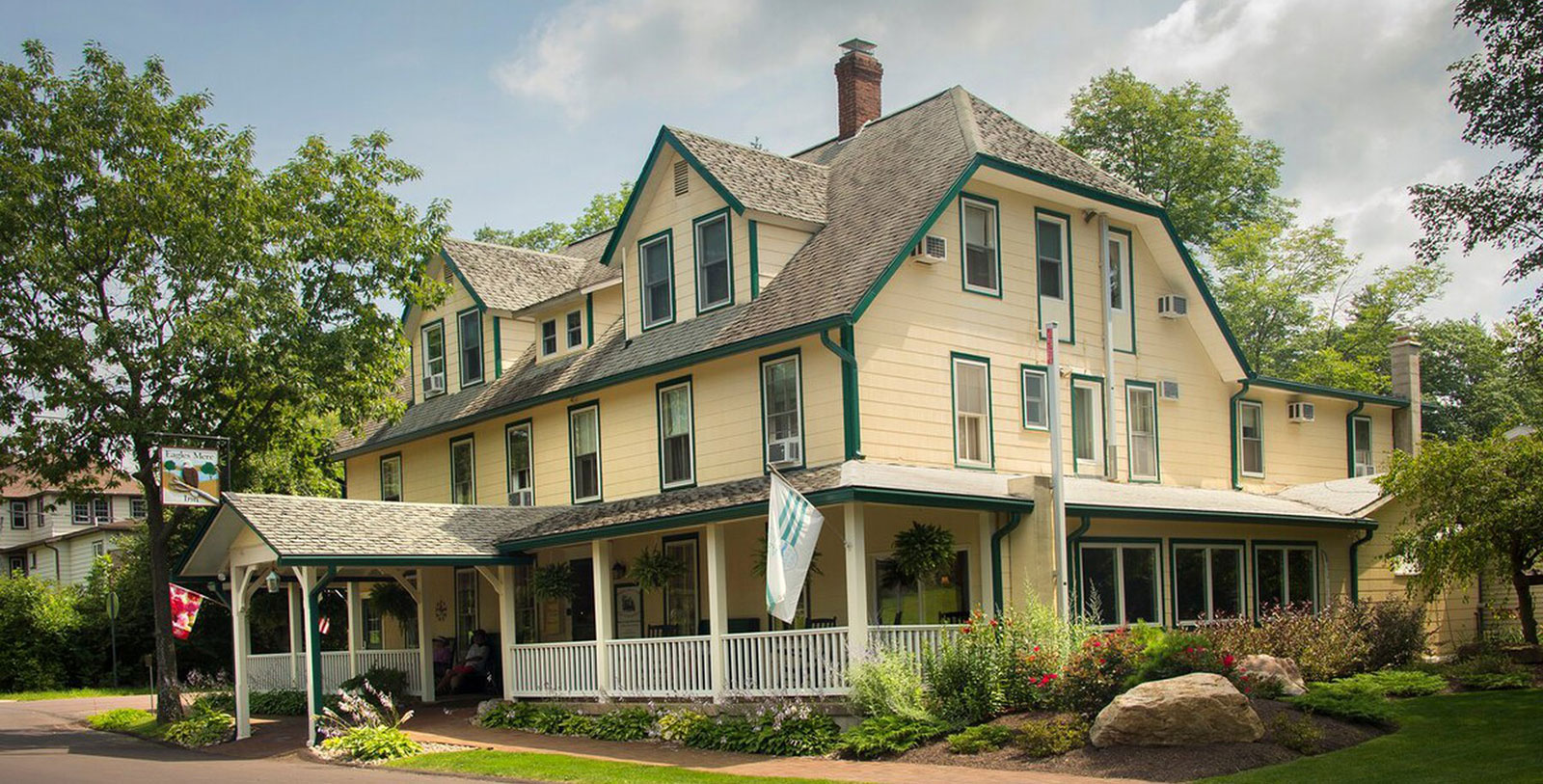 a large yellow house with a white railing with Grover Cleveland Birthplace in the background