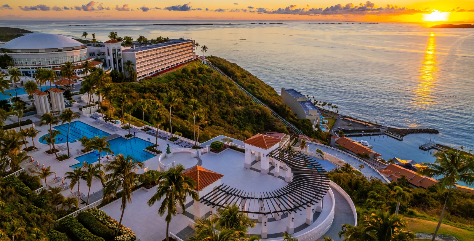 a resort with a pool and a building on a hill