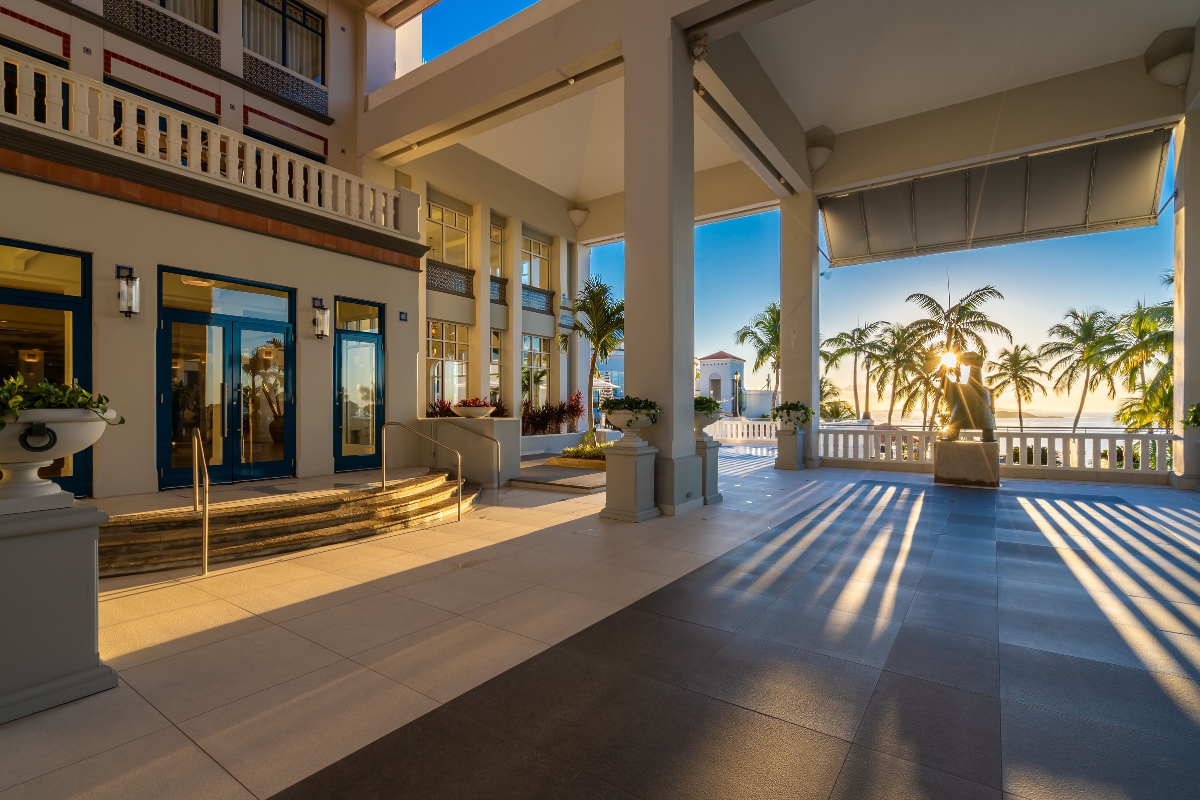 a building with a staircase and palm trees