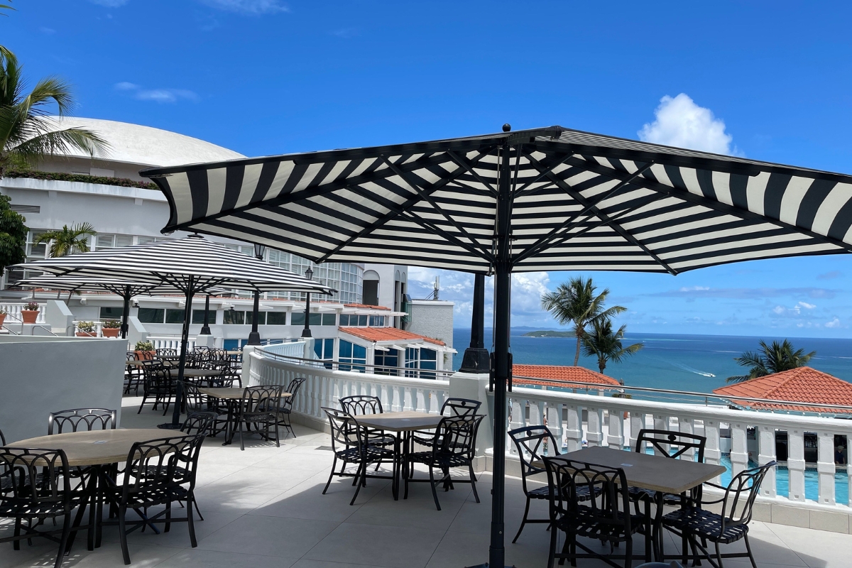 a patio with tables and umbrellas on a sunny day
