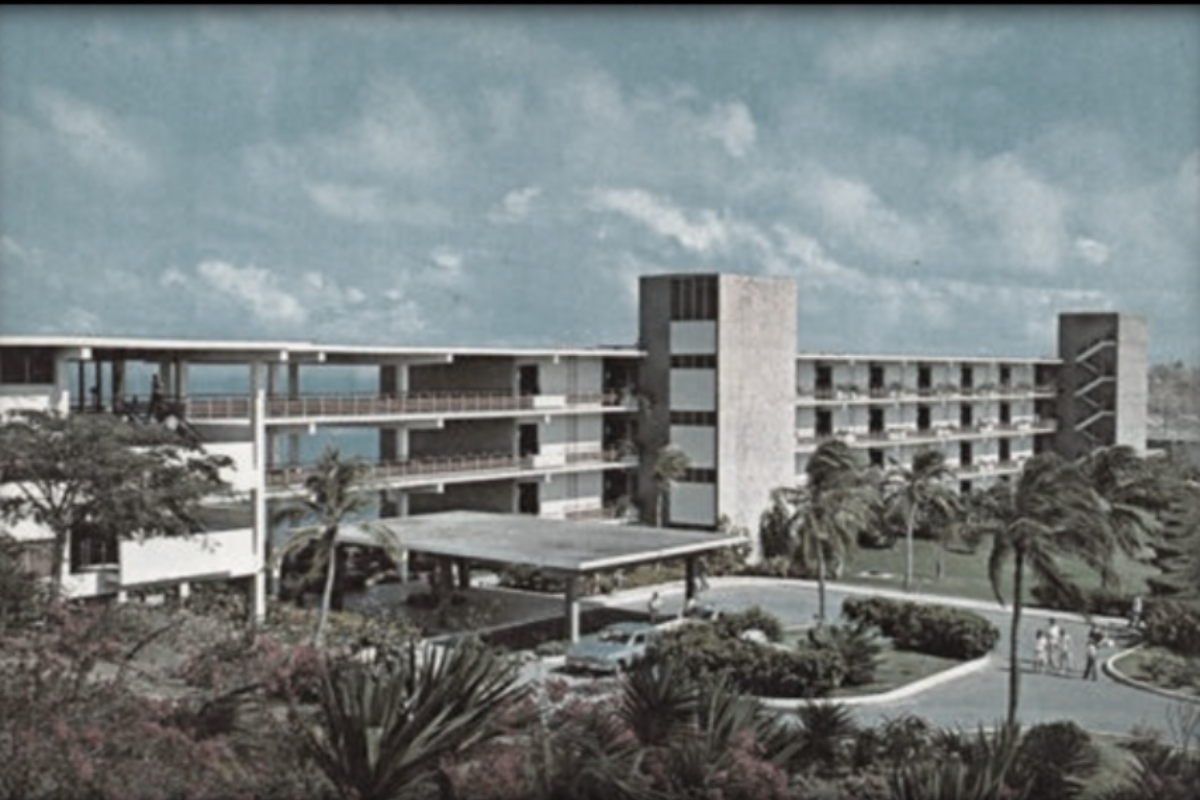 a building with a parking lot and palm trees