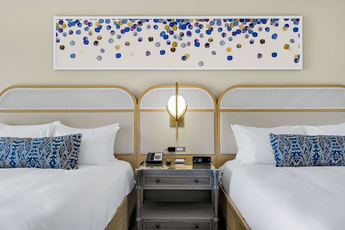 a room with two beds and a lamp