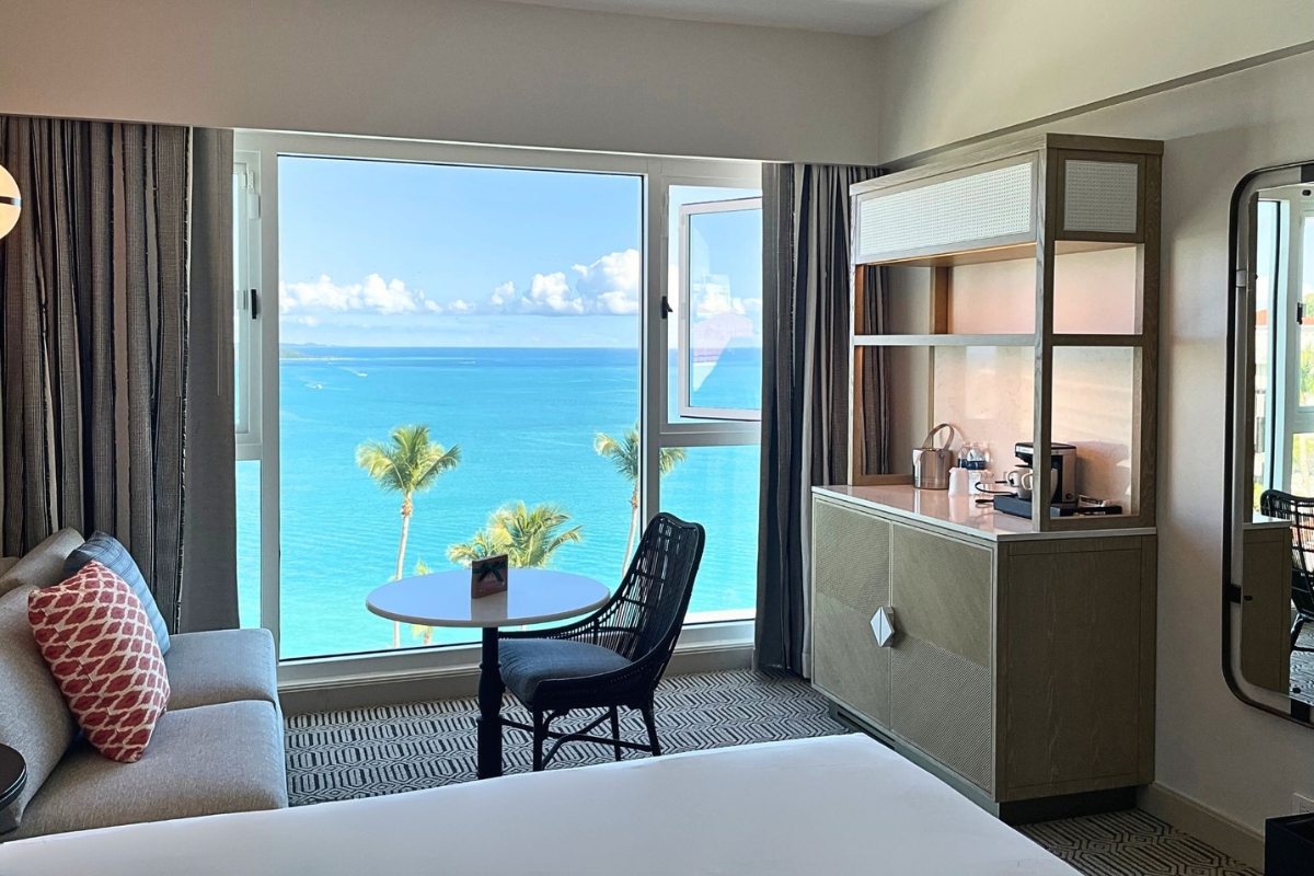 a room with a table and chairs and a large window overlooking the ocean
