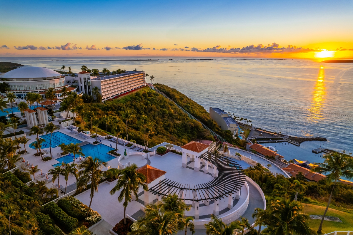 a resort with a pool and a body of water