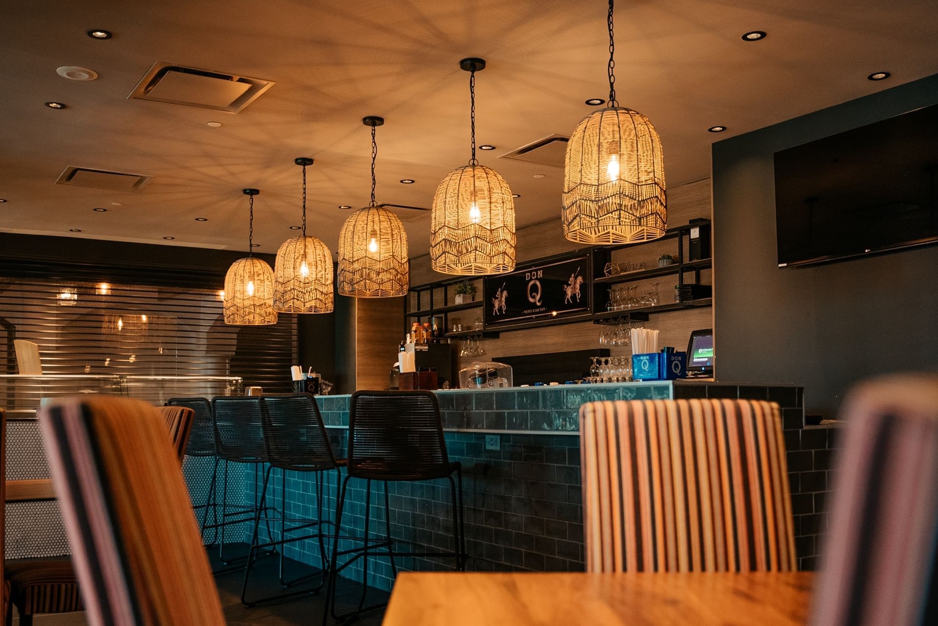 a bar with chairs and a light fixture