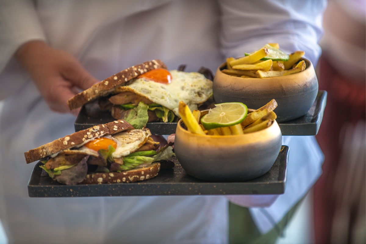 a tray of food with a person holding a tray of food