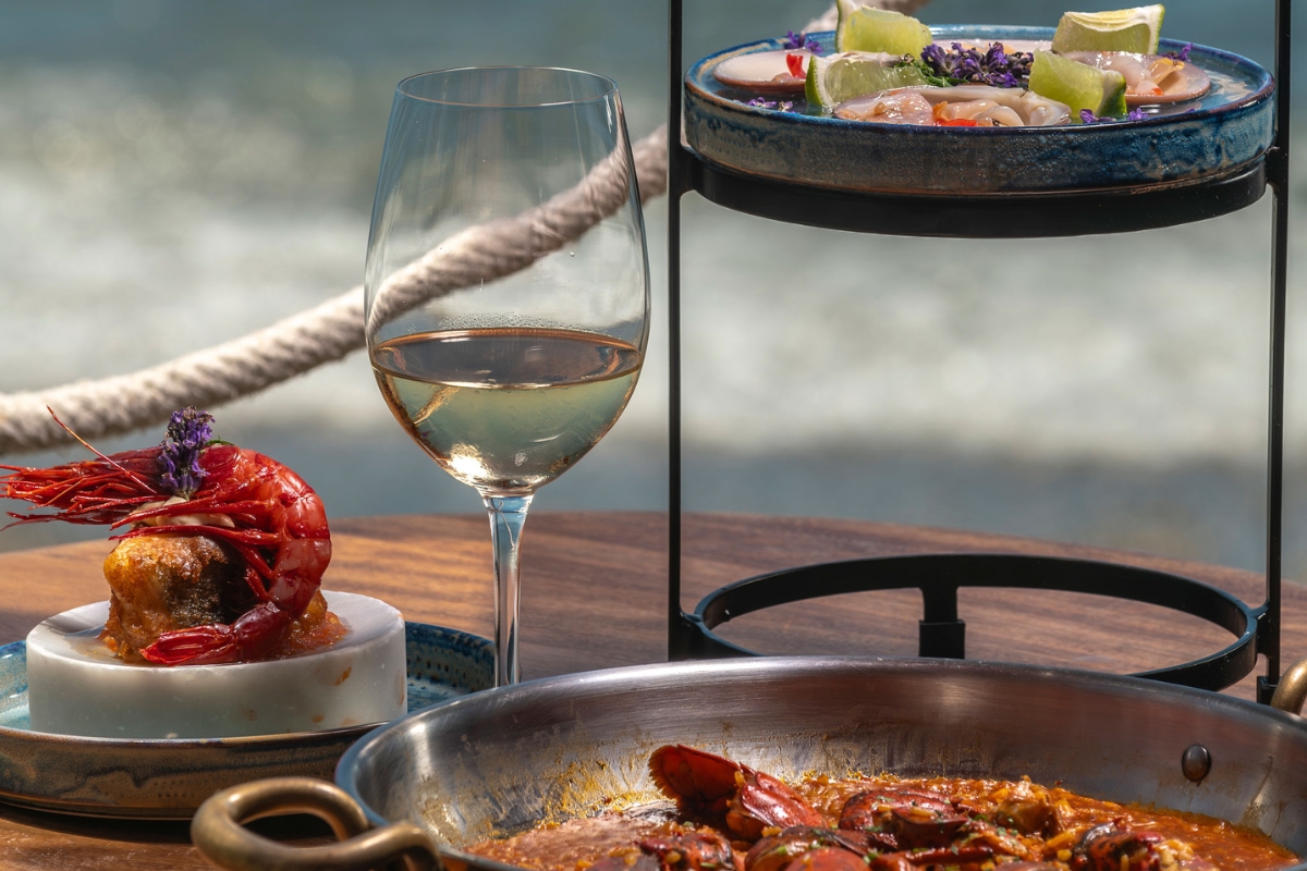 a glass of wine next to plates of food