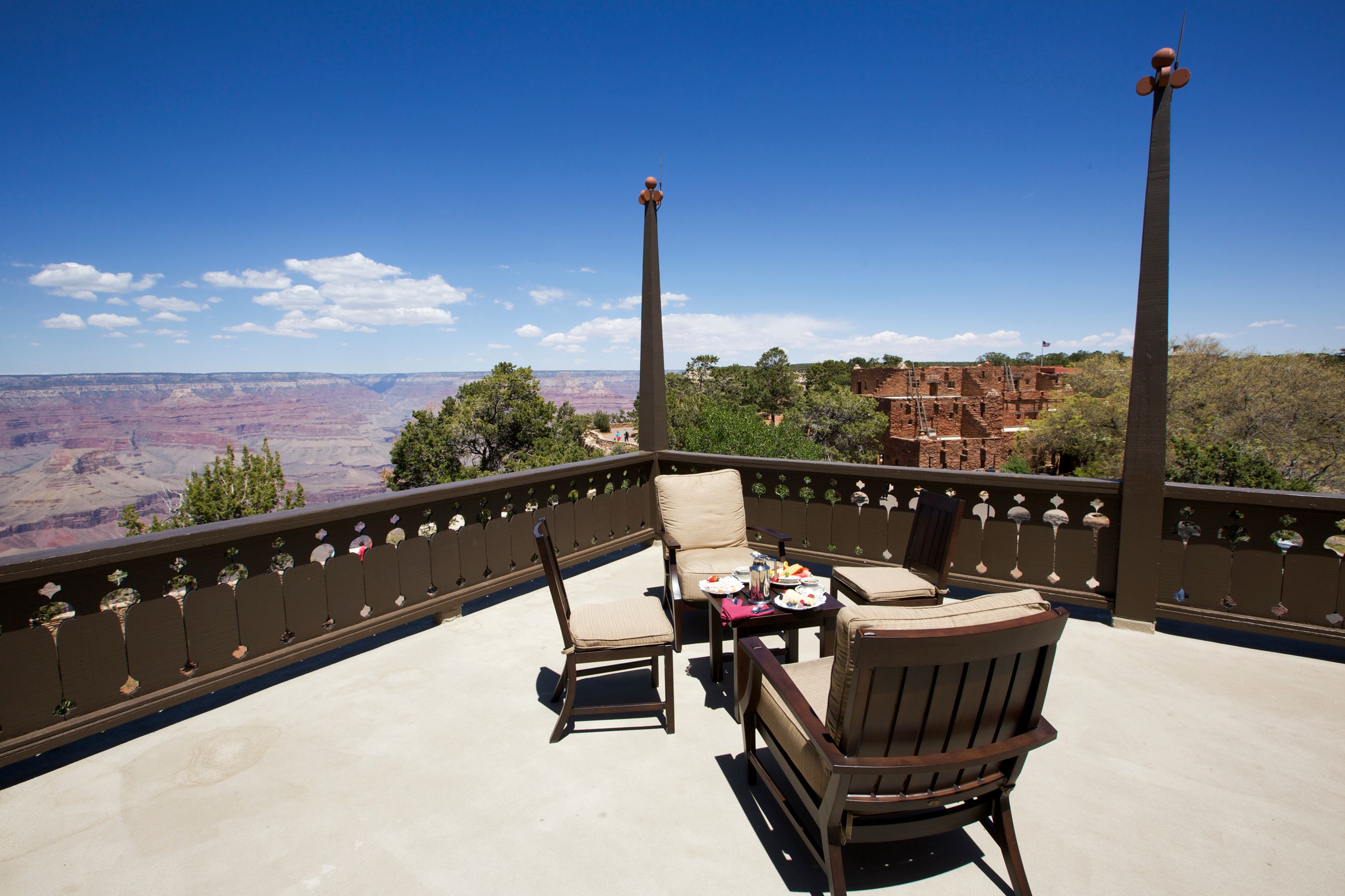 a table and chairs on a deck overlooking a canyon