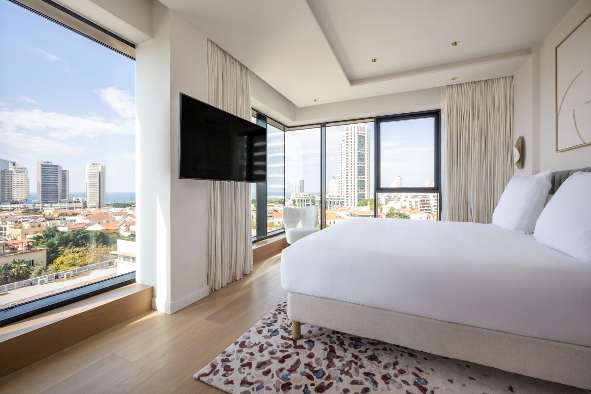 a bedroom with a large television and a city view