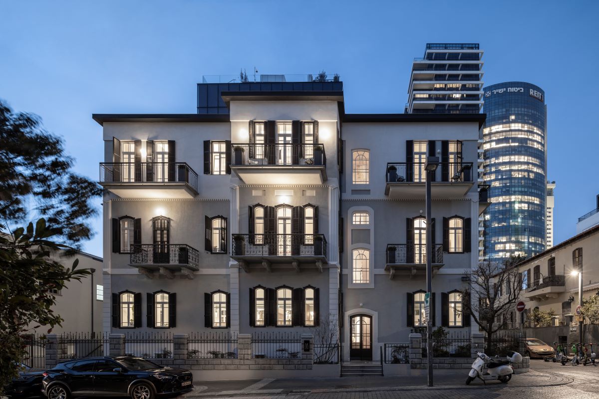 a building with many windows and a car parked on the street