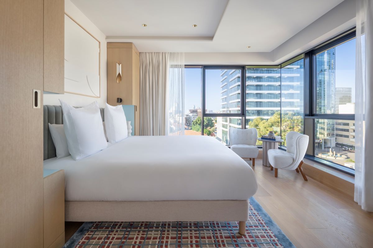 a bedroom with a large bed and chairs