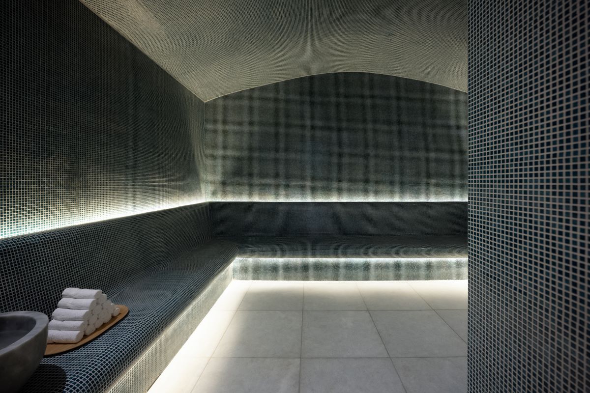 a sauna with a bench and a tile floor