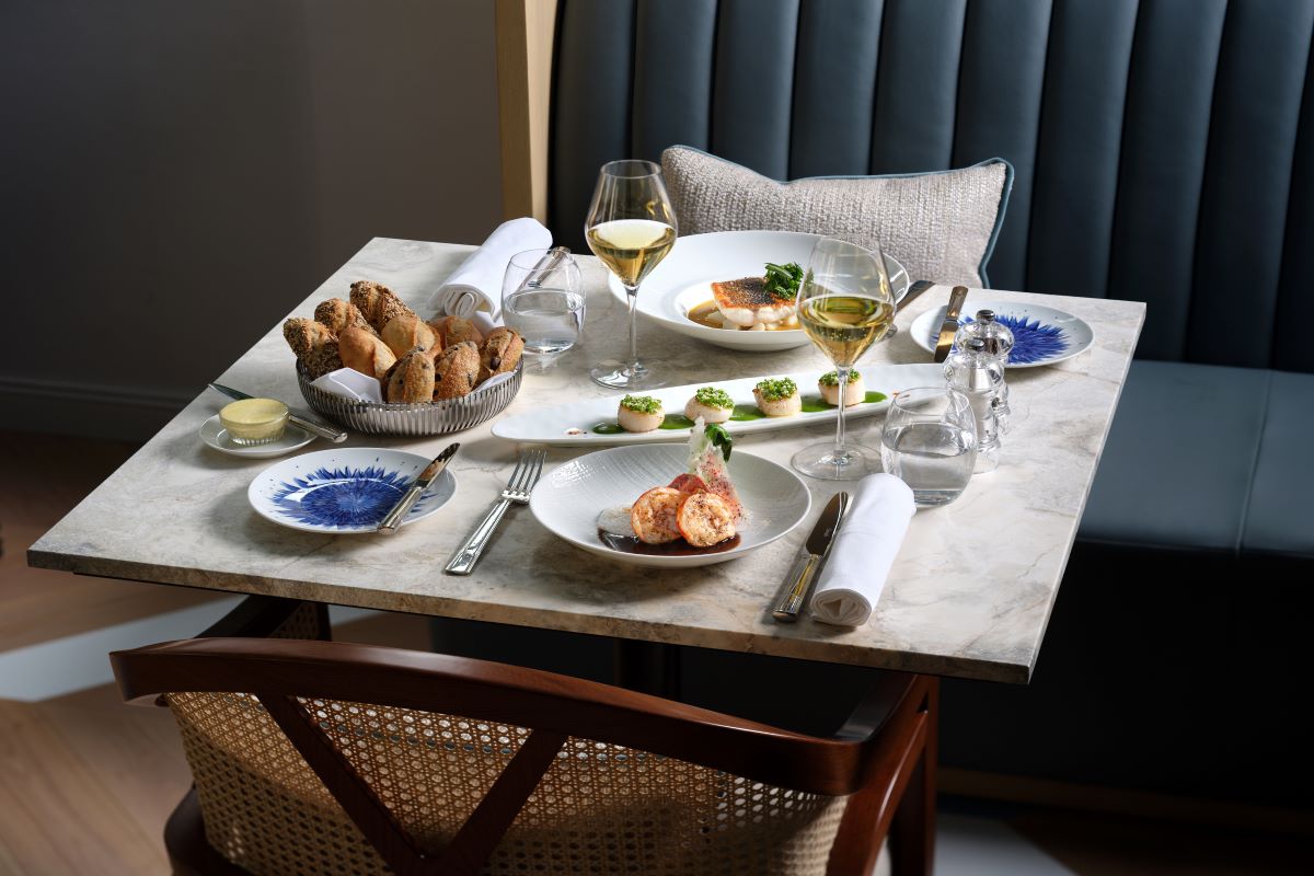 a table with plates of food and glasses of wine