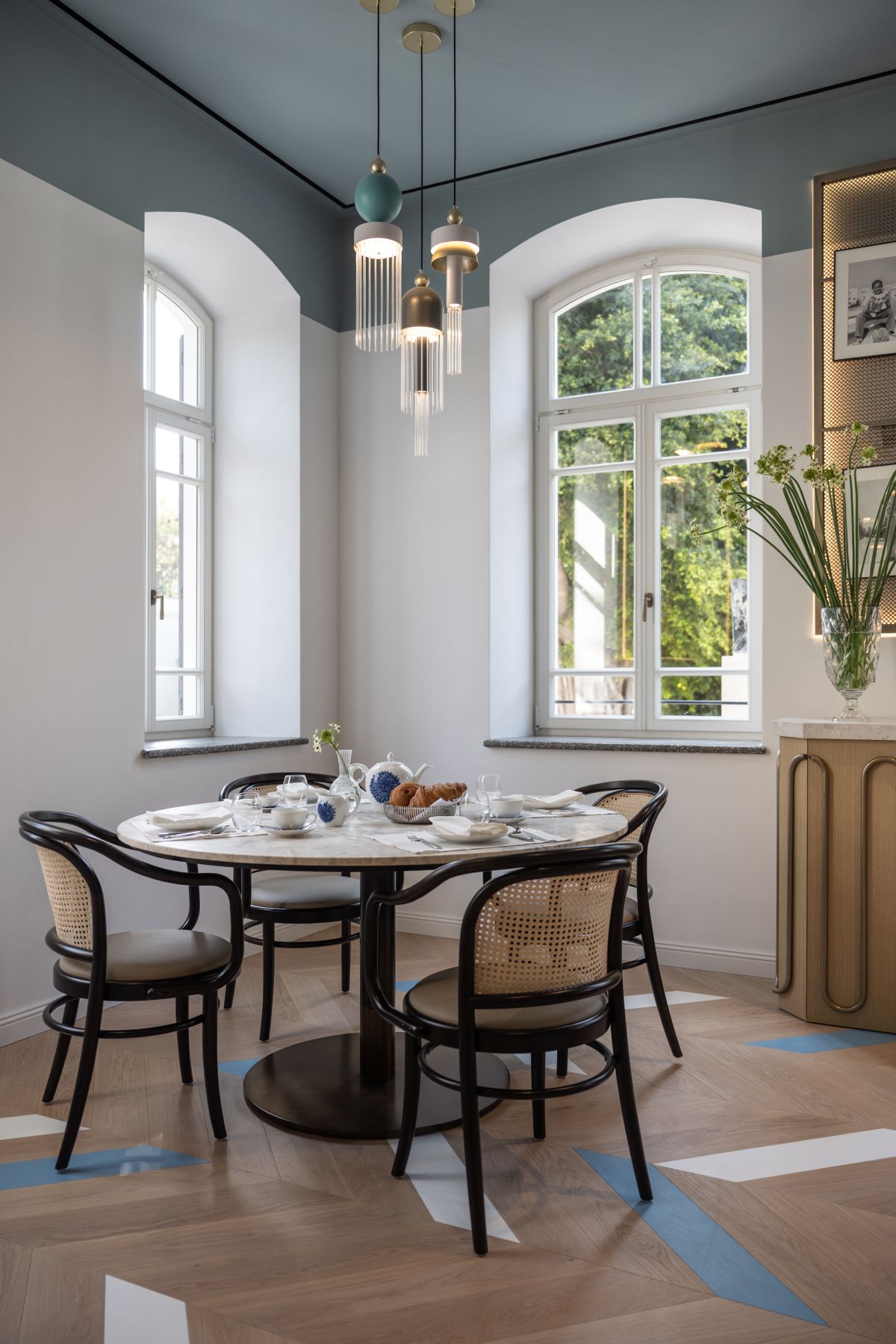 a dining table with chairs and a vase of flowers