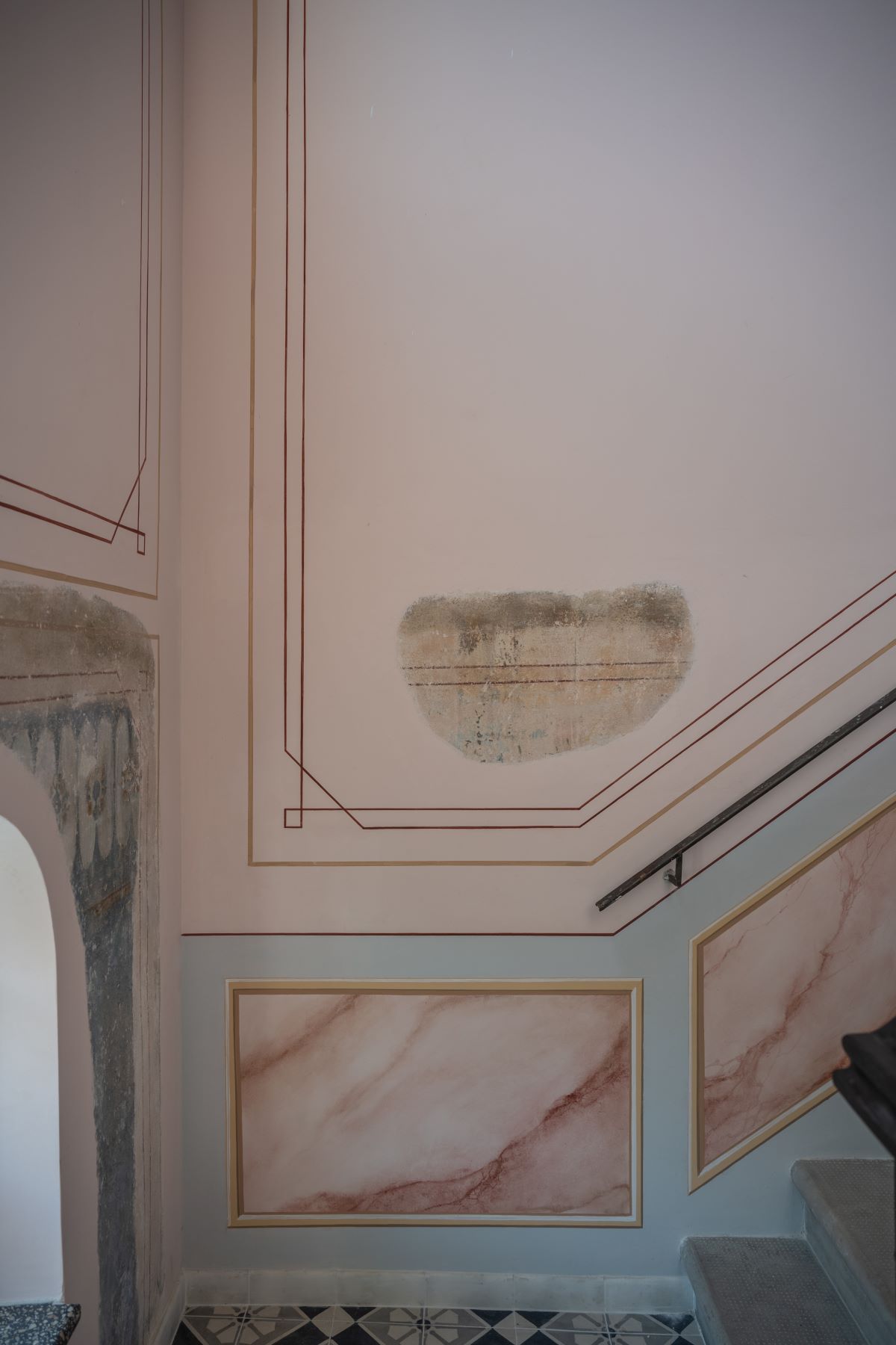 a staircase with a pink wall and a red line on the wall