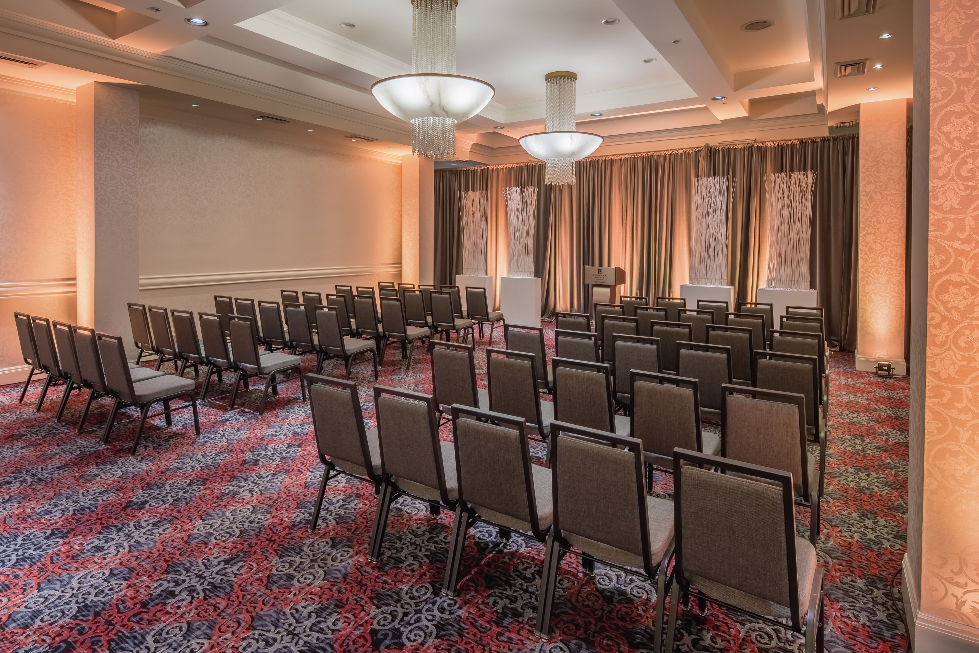 a room with chairs and chandeliers