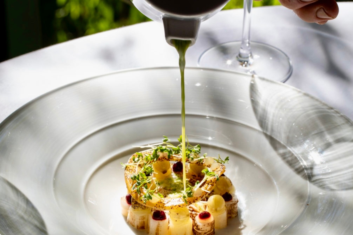 a plate of food with a sauce being poured into it